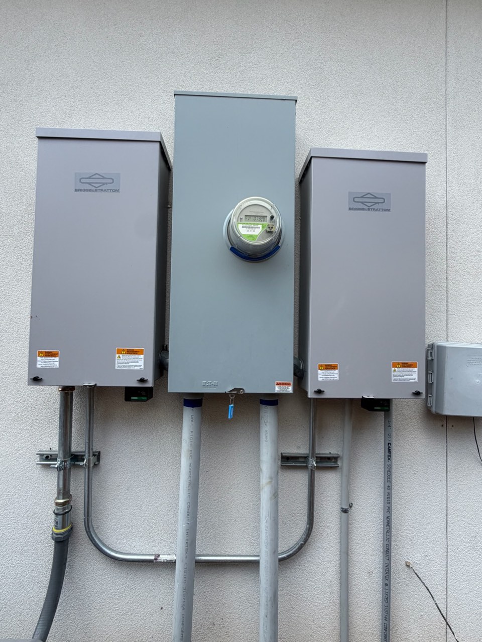Briggs and Stratton automatic transfer switches flanking the meter, installed by VCG Electrical in Houston